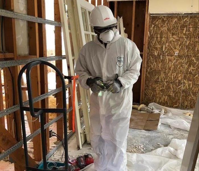 Crew Chief in his Personal Protective Equipment doing demolition.