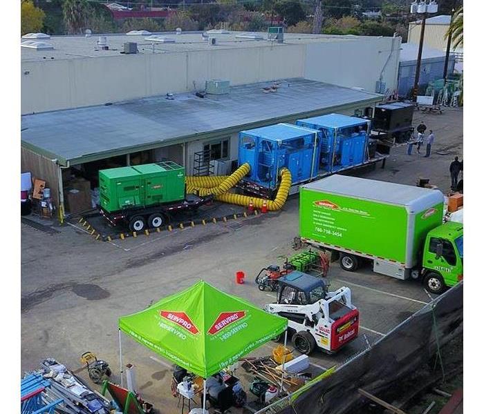 Aerial shot of green work trucks at middle school flood.